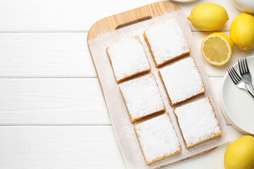 Tasty lemon bars and fresh fruits on white wooden table, flat lay. Space for text
