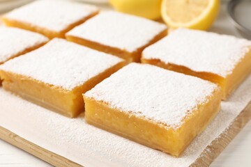 Tasty lemon bars and fresh fruits on table, closeup
