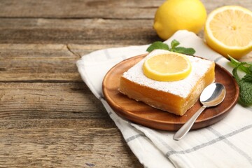 Tasty lemon bar with mint and fresh fruits on wooden table, closeup. Space for text