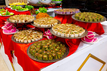 Cig kofte (raw meatball) with lettuce, tomato, pickle and lemon, hot Chee kofta. Turkish local raw food concept.Table scene of assorted take out or delivery foods. Doritoslu dublecig kofte durum.