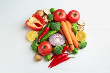 Different fresh raw vegetables and lemon on white wooden table, flat lay