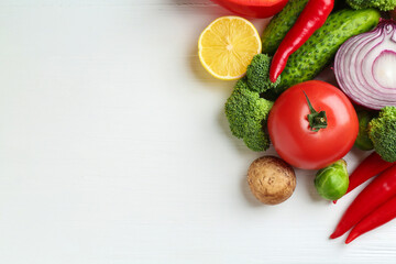 Different fresh raw vegetables on white wooden table, flat lay. Space for text