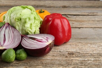 Different fresh raw vegetables on wooden table, closeup. Space for text