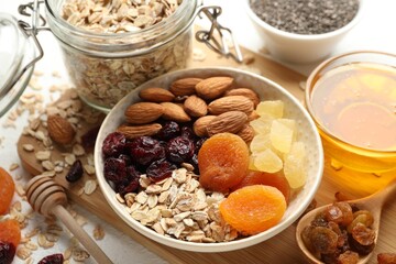 Making granola. Oat flakes, dried fruits and other ingredients on white table, closeup