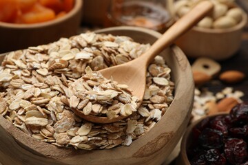 Making granola. Oat flakes, dried fruits and other ingredients on table, closeup