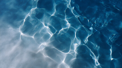 Clear water with gentle ripples reflecting sunlight, creating serene and tranquil pattern on sandy surface, top flat view, blue and white tones