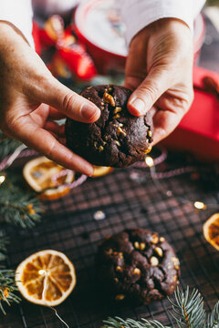 Homemade chocolate nut cookie held by hand during festive holiday season