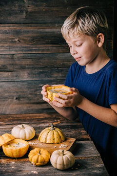 Child preparing pumpkin indoors with fall decor and thanksgiving prep