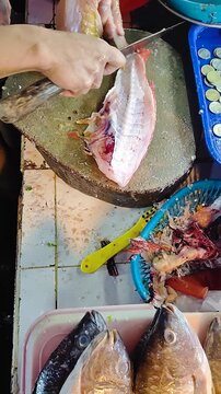 Cleaning the lapu-lapu fish. Traditional fish market. Iligan, Philippines. Vertical view.