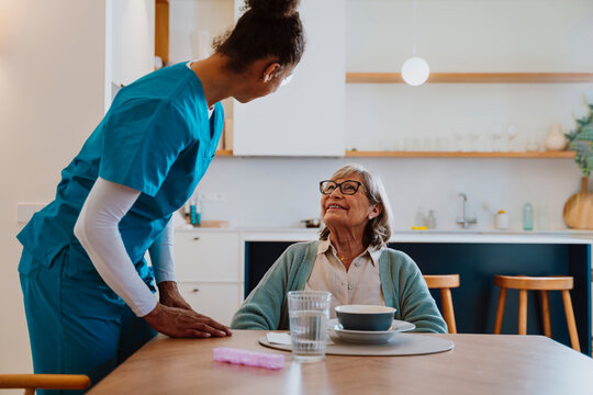 Nurse providing care and companionship during a meal at home