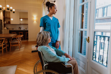Caregiver providing compassionate assistance to elderly woman in wheelchair