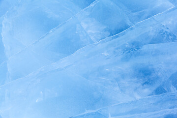 Winter natural ice background of frozen Baikal Lake in cold day. Blue ice texture with pattern of white cracks. Natural icy backdrop for Christmas design. Mockup, copy space, flat lay, blank, top view