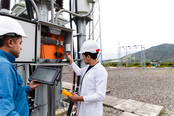 Engineers conducting a transformer voltage check at a wind farm