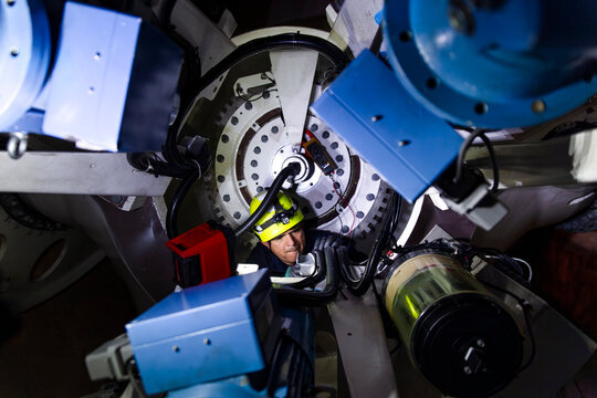 Engineer performing maintenance on a wind turbine nacelle rotor indoors
