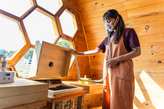 Person inhaling bee air with breathing mask during apitherapy indoors