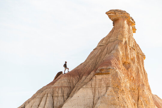Trekking with backpack at sunrise in Bardenas Reales desert landscape