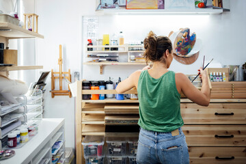 Artist preparing workspace in art studio back view