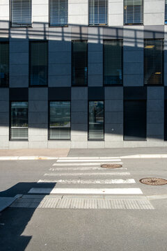 Architecture facade with windows forming pattern under sunlight and shadow in a minimalism composition that highlights geometry, structure and a crisp contrast across the scene