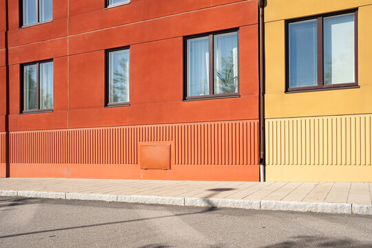 Architecture facade with strong color and direct sunlight forming shadow across windows, bringing geometry, minimalism, structure and a vivid contrast throughout the scene