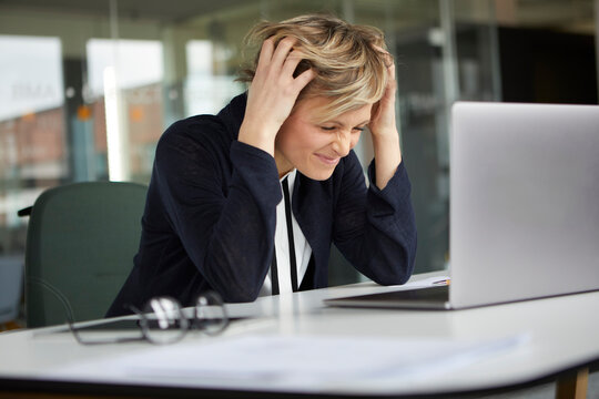 Businesswoman feeling frustrated at work in a modern office setting