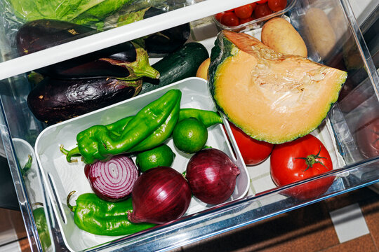 Fresh vegetables and fruits organized in fridge vegetable drawer