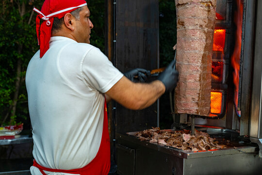 Meat rotisserie at the luxury hotel's buffet. A rotisserie chef is carving traditional Turkish rotisserie meat.Hatay usulu et tavuk doner durum. Lavash doner kebab ( zurna  durum )  or shawarma sliced