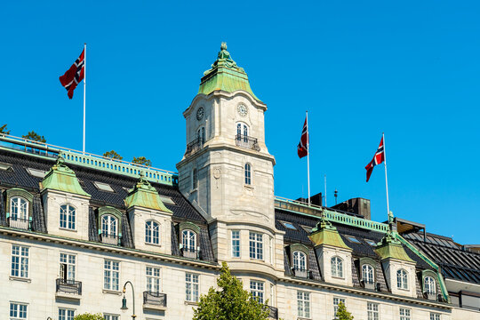 Luxury hotel building with Norwegian flags in Oslo during summer