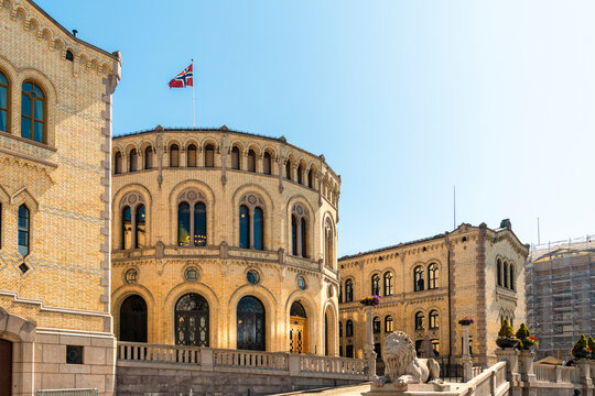 Parliament building in Oslo with Norwegian flag under blue sky