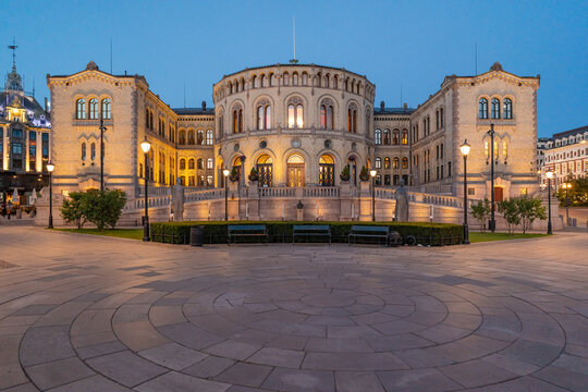 Illuminated parliament building in Oslo at night with blue sky