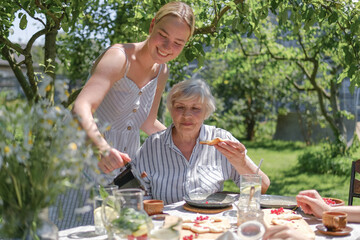 Family enjoying breakfast together in a garden on a sunny day