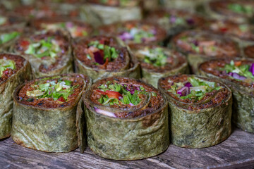 Fototapeta premium Cig kofte (raw meatball) with lettuce, tomato, pickle and lemon, hot Chee kofta. Turkish local raw food concept.Table scene of assorted take out or delivery foods. Doritoslu dublecig kofte durum.