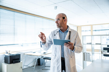 Doctor using AR glasses and tablet in modern clinic office