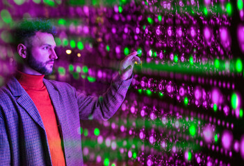 Engineer analyzing data on interactive technology wall in server room