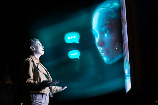 Engineer communicating with AI chatbot hologram using digital technology