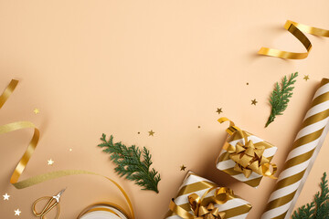 Christmas gift wrapping with golden and white striped wrapping paper, ribbon, scissors, and small gift boxes on beige backdrop. Copy space.
