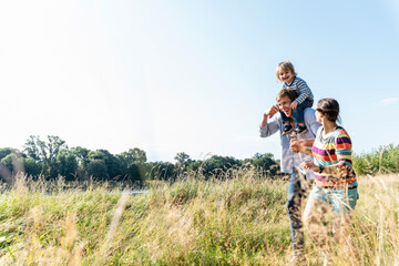 Happy family enjoying outdoor walk by river in nature