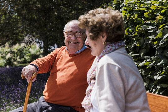 Smiling senior couple enjoying conversation outdoors in nature - Powered by Adobe