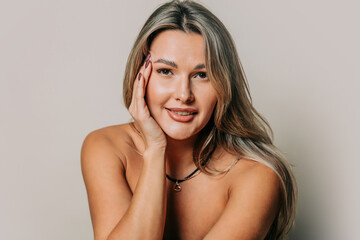 Smiling woman with makeup in studio portrait showcasing beauty and skincare