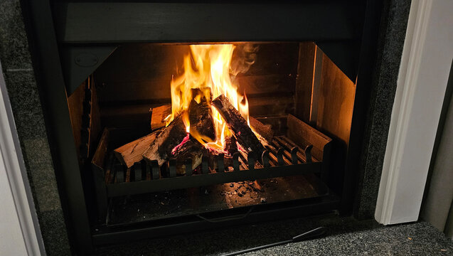 fireplace with wooden logs resting on the grate, ready to be lit concept - Powered by Adobe