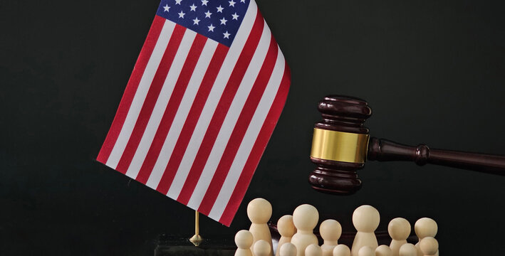Judge gavel and flag of United States of America and society or migrants