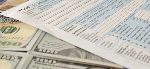 Obraz premium US tax form, specifically form 1040, on top of multiple 100 bills concept