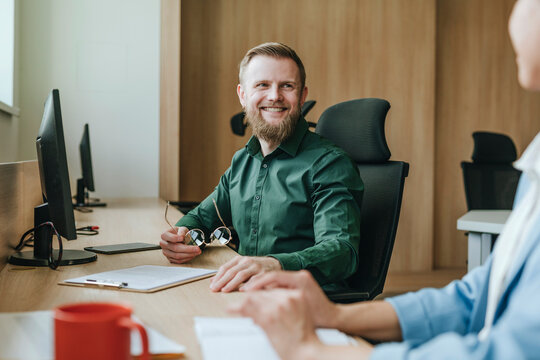 Colleagues discussing work at a modern office desk