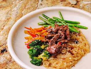 Savoring a colorful plate of stir-fried beef and vegetables with noodles