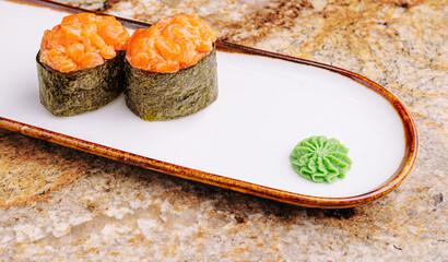 Delicious sushi garnished with wasabi on a marble surface