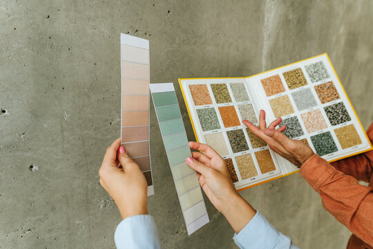 Couple selecting wall plaster samples for interior renovation indoors