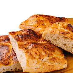 Freshly baked bread rolls resting on a wooden board in bright light