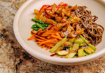 Colorful Asian noodle dish with vegetables and chicken served in a bowl