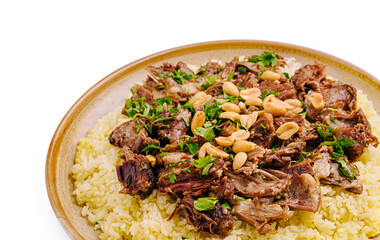 Savory dish of tender meat served on a bed of seasoned rice with herbs and nuts