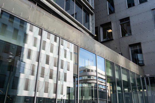 Reflection and geometry defining a modern architecture facade enriched by symmetry, structure, minimalism, coordinated urban design and articulated architectural detail