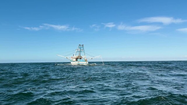 Commercial Fishing Trawler Navigates Ocean Channel at Sunset